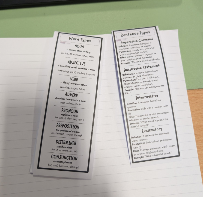 Two printed sheets of educational material on a notebook page.